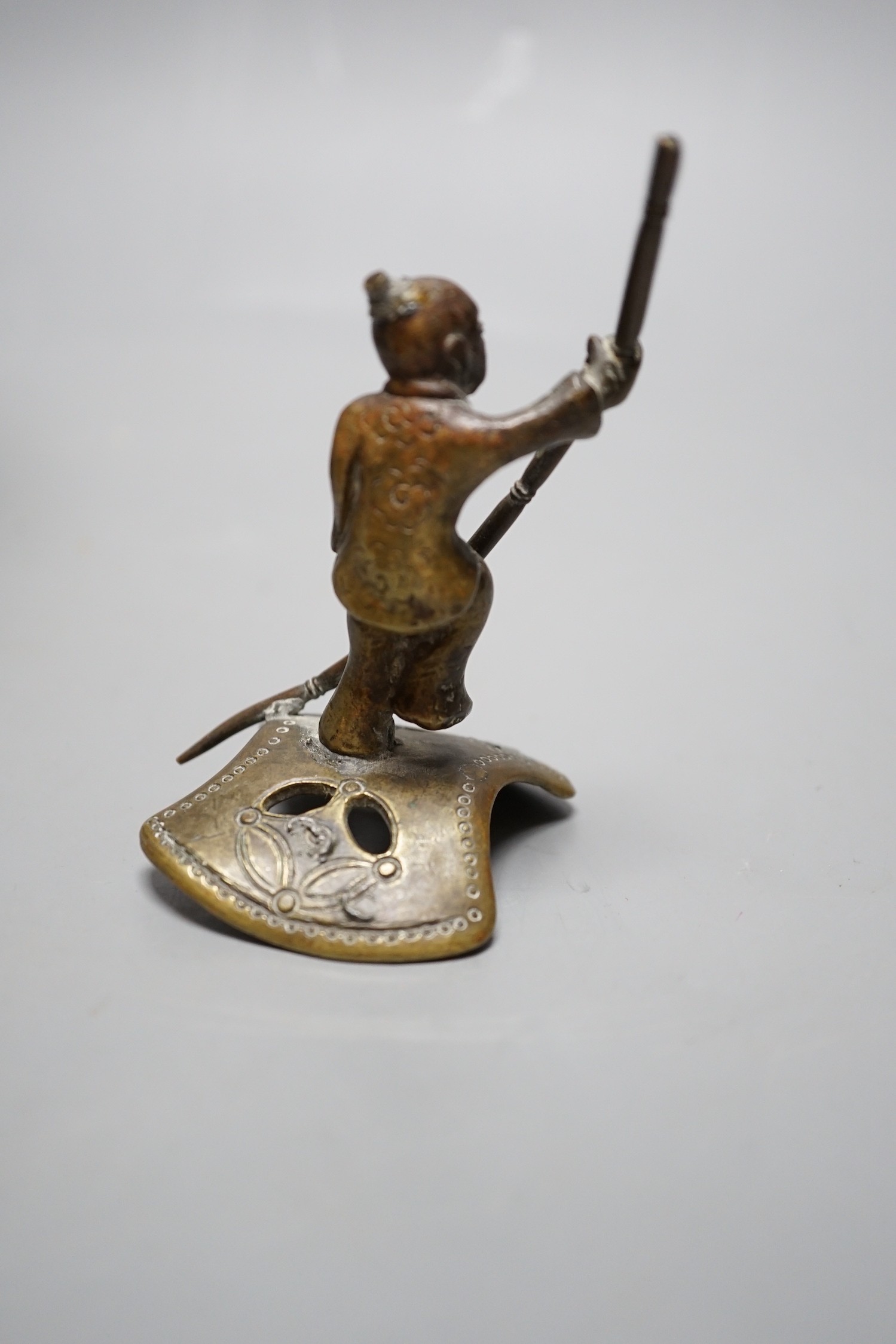 A Chinese green and russet jade belt buckle, an archaistic bronze tripod vessel and a figural bronze. Tallest 25cm